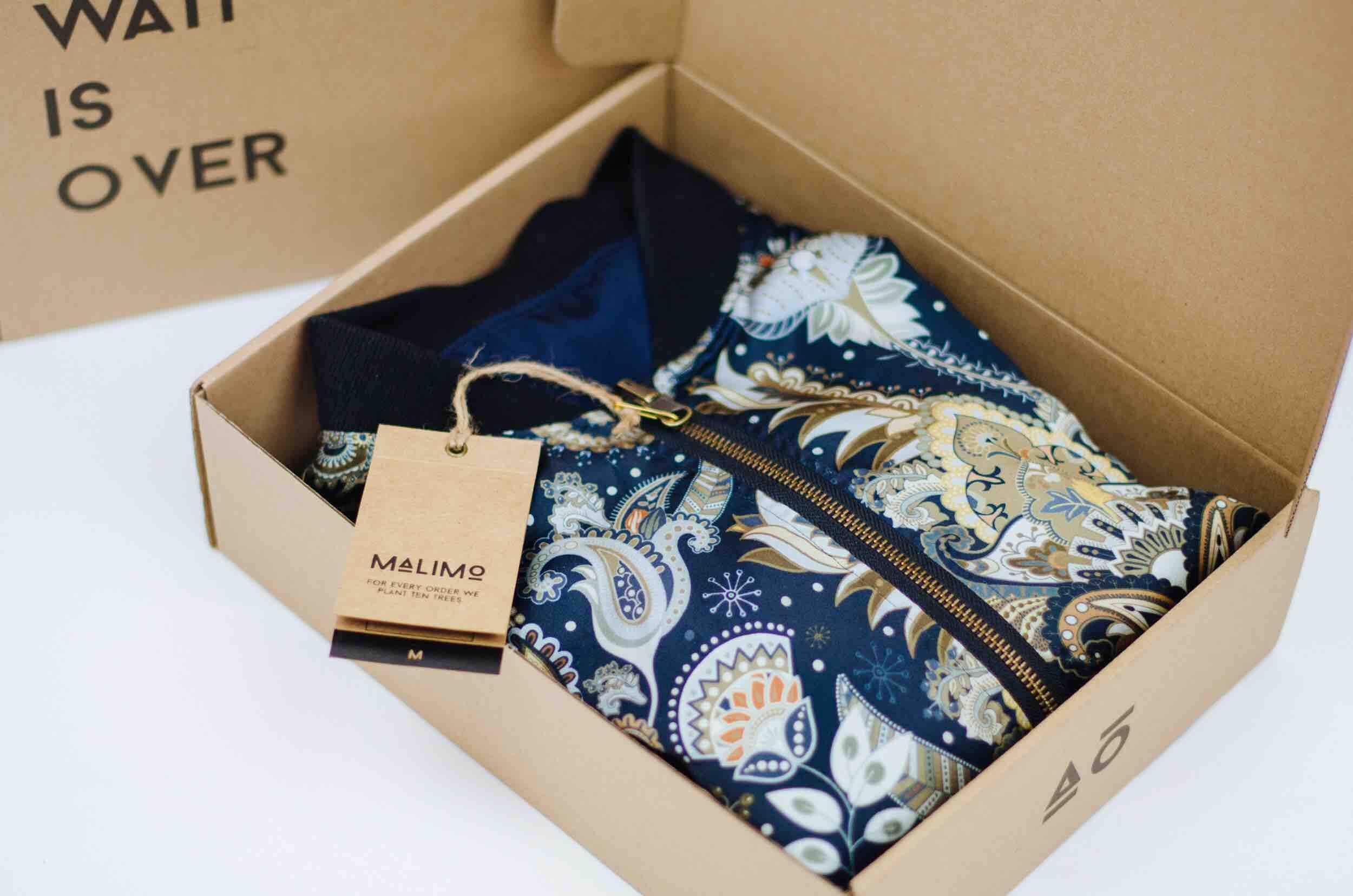 open cardboard box with piece of clothing inside - packhelp