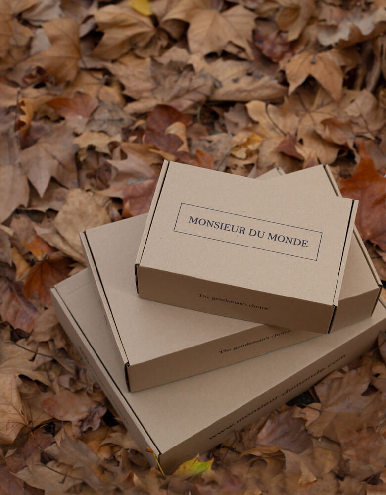 Empilement de boîtes Monsieur du Monde sur des feuilles mortes