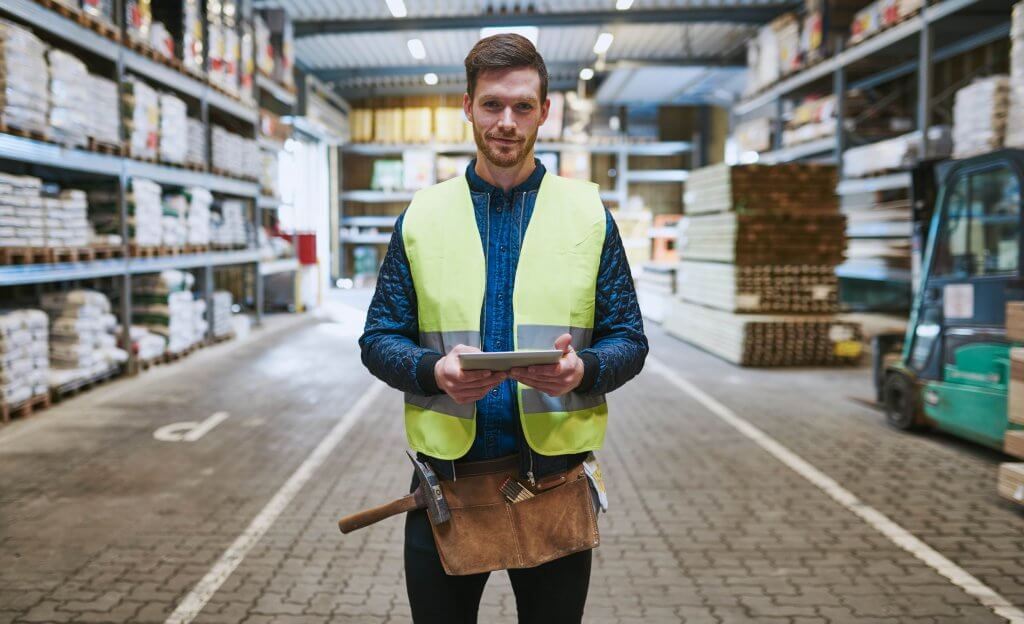 A worker standing in a supply chain packaging production facility.